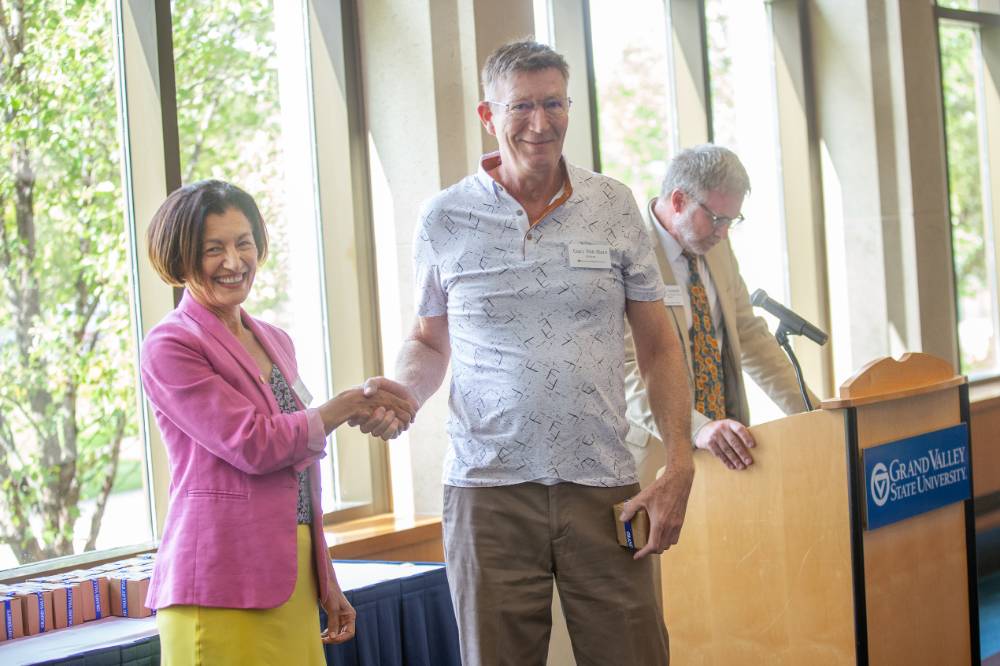 Provost Mili and a Retiree shaking hands.
